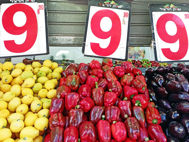 Large size red paprikas and other fresh vegetables are displayed for sale on a market stall at Tel Aviv famous food market Shuk HaCarmel.