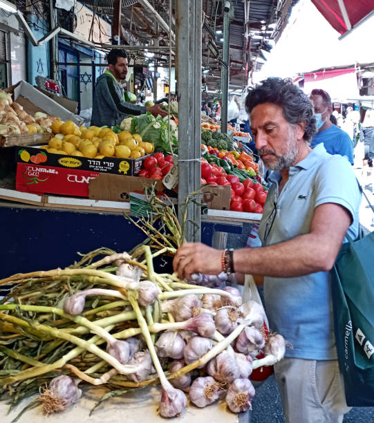 mężczyzna kupuje najlepszy świeży czosnek na rynku. - spice market israel israeli culture zdjęcia i obrazy z banku zdjęć