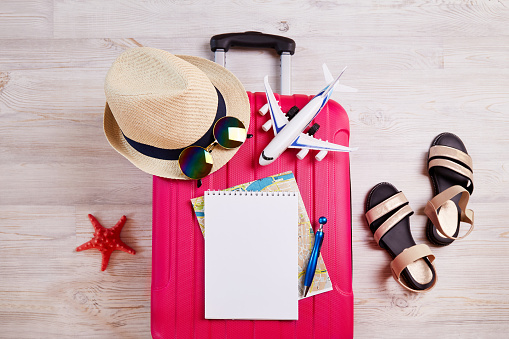 Una maleta con cosas y accesorios para unas vacaciones. Viajes de verano, preparación para el viaje, embalaje de equipaje. photo