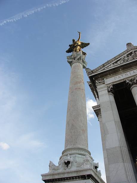 Statue of Christopher Columbus standing atop the Columbus Monument, reaching towards the sea under a vibrant blue sky with wispy clouds, symbolizing exploration, travel, and historical landmarks