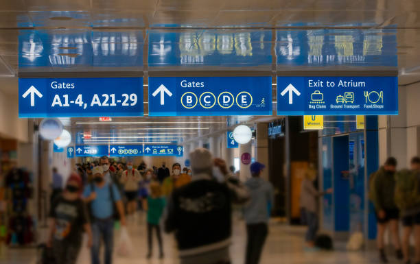 Busy Terminal 2 Airport Terminal signs with rushing commuters airport terminal stock pictures, royalty-free photos & images