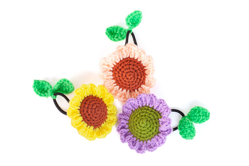 Crocheted rubber hair band sunflower made from yarn isolated on white background.