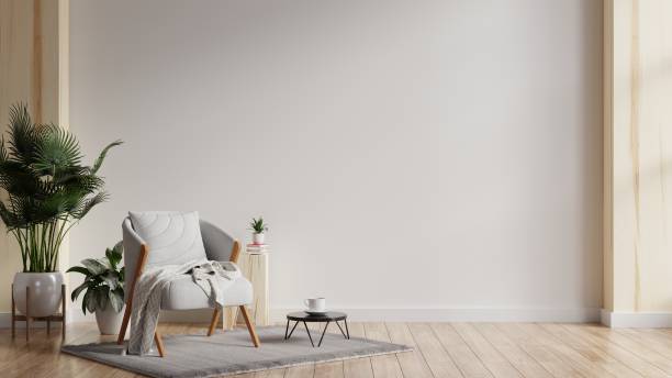 interior minimalista moderno con un sillón gris sobre fondo de pared blanco vacío. - simple living fotografías e imágenes de stock