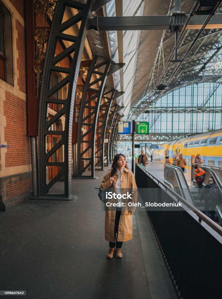 Woman waiting for the train on railway station Young Caucasian woman waiting for the train on railway station Commuter Stock Photo