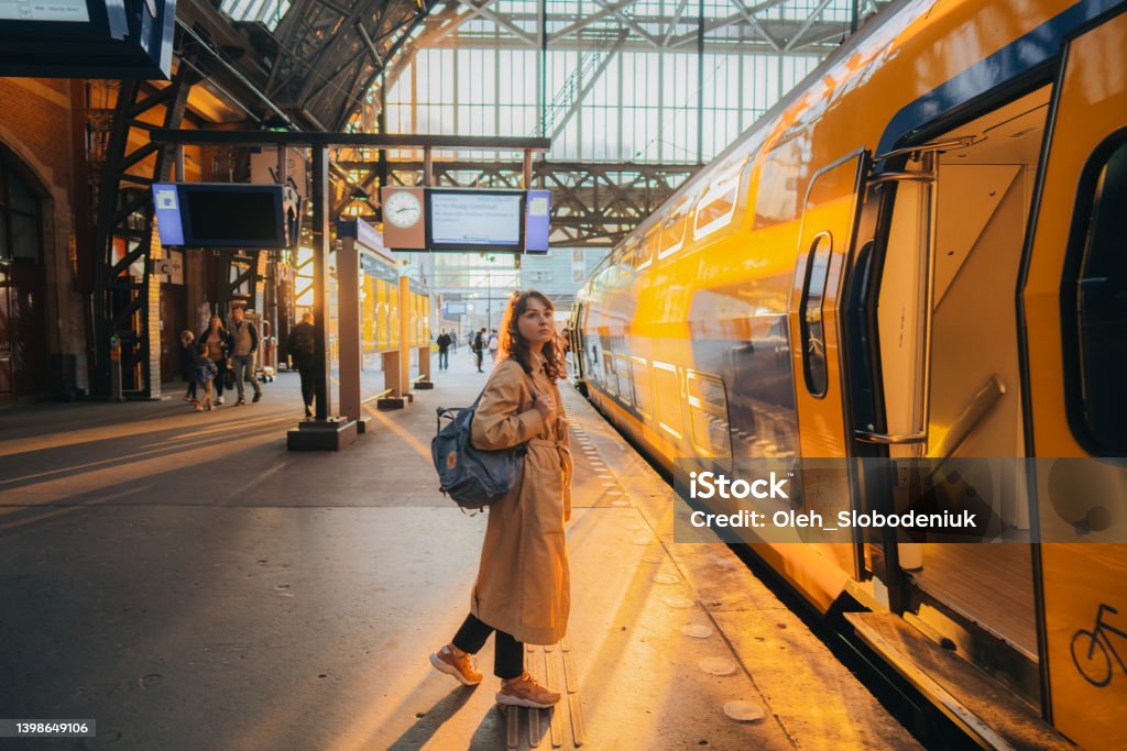 Woman waiting for the train on railway station Young Caucasian woman waiting for the train on railway station Netherlands Stock Photo