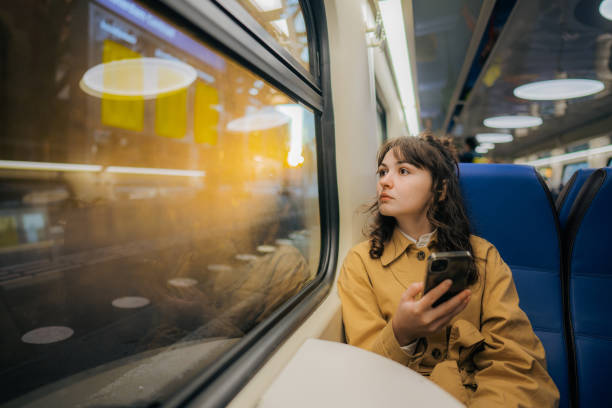 Woman using  smartphone while  traveling in the train