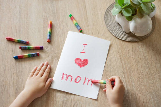 istock Children's hands draw a greeting card for Mother's Day. 1398654146