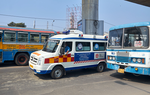 Kolkata, 02-19-2022: An ambulance of South Eastern Railway Central Hospital speedily overtaking a bus while carrying patient during an emergency situation. Near Ruby more, EM Byepass.