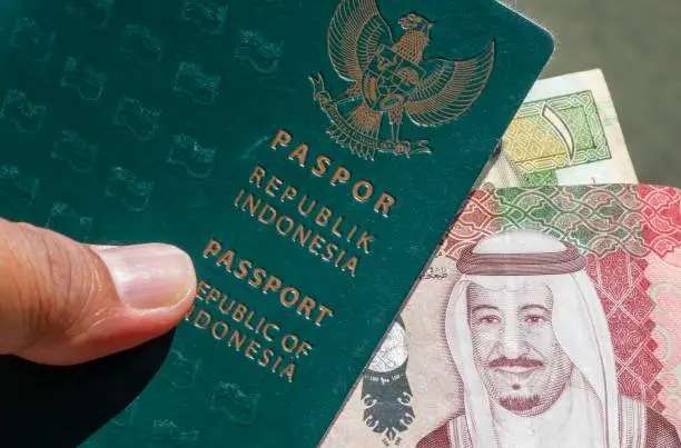 Close up of the Indonesian green passport book and The Saudi Riyal, the currency of Saudi Arabia, for the preparation of pilgrims from Indonesia