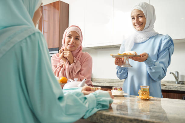 istock Friendly Muslim lady offering tasty pastry and smiling 1398659130