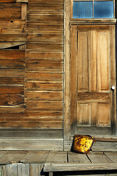 Arrugginito Bucket & città fantasma portiera - foto stock