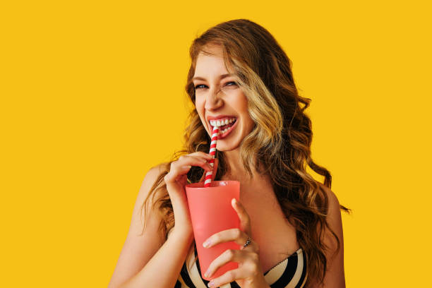 hermosa joven con cóctel sobre fondo de color - drinking straw drinking juice women fotografías e imágenes de stock
