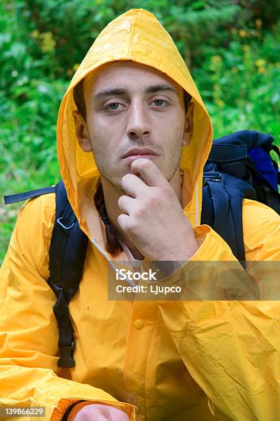 Foto de Mochileiros Em Um Casaco Comprido Amarelo Descanso e mais fotos de stock de Acampar - Acampar, Adolescente, Adolescência