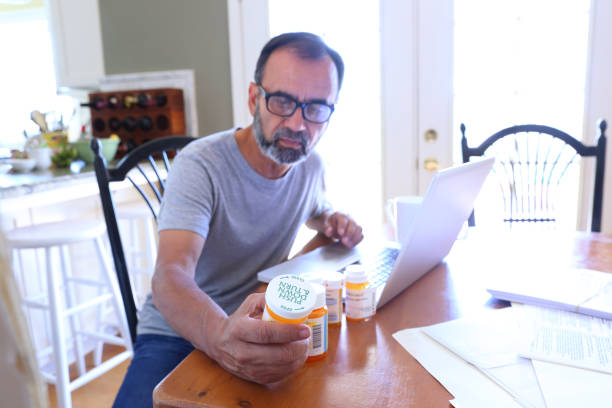 istock Hispanic Man Sitting At Dining Room Table Reading About His Medication On His Computer 1398662332