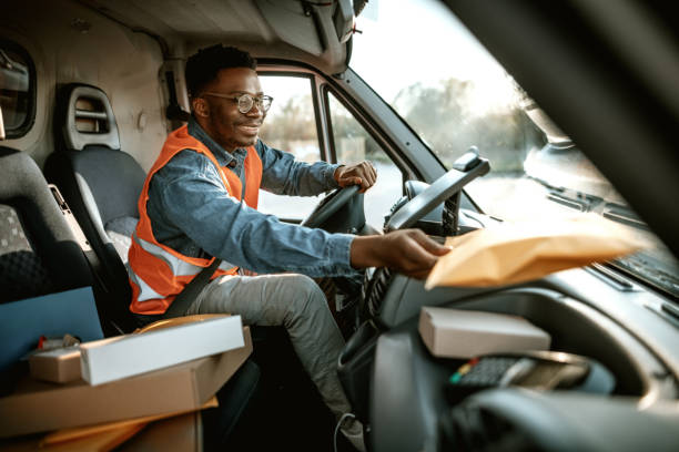 istock Young smiling delivery driver checking packages inside of delivery van 1398663374