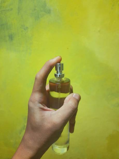 istock a person's hand holding a perfume bottle 1398665275