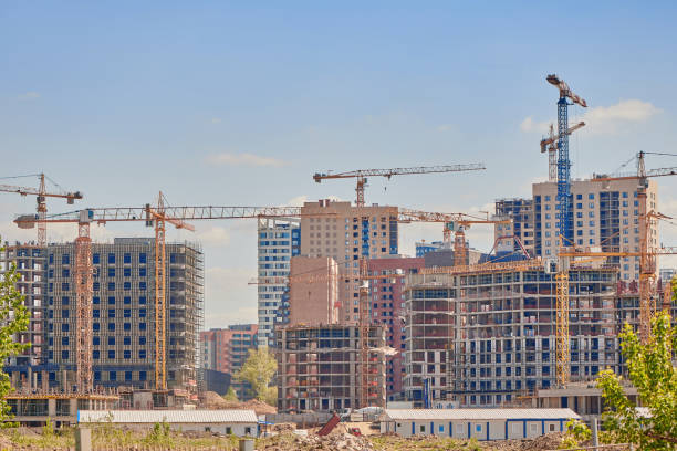 istock Group of tower cranes on the construction site against blue sky. Cranes for construction of high-rise buildings. Real estate construction. Concept of urban development and architecture. 1398665625