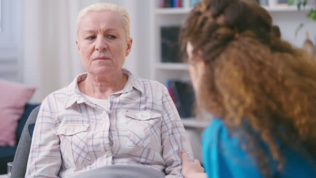 Lonely senior woman feeling sadness, refusing to talk and take medication