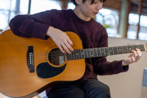 istock A man in his twenties practicing playing the guitar 1398666923