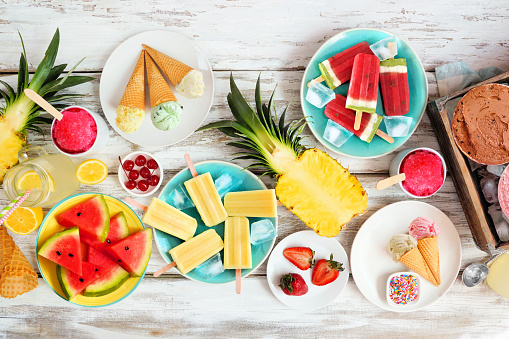 Close-up of variety of fruits in a plate with cheese slices, milk, honey. Full healthy breakfast served on table.