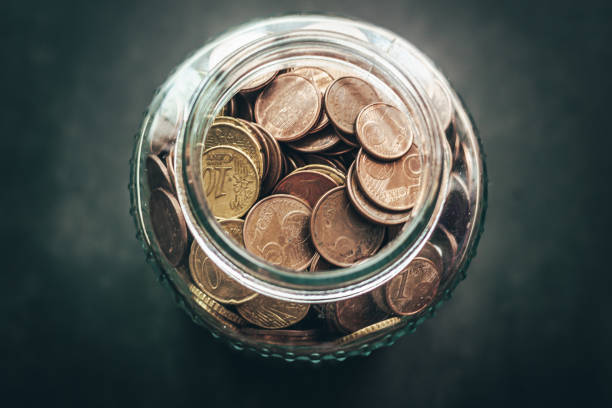 frasco de vidrio lleno de monedas de dinero, euros. - jar coin currency glass fotografías e imágenes de stock