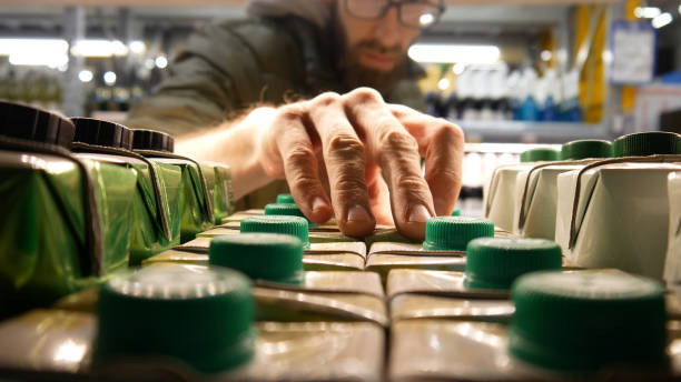 Close-up of carton packaging of wine on a store shelf and a man takes one Many carton packaging of wine on a store shelf close-up and a male buyer takes one juice carton stock pictures, royalty-free photos & images