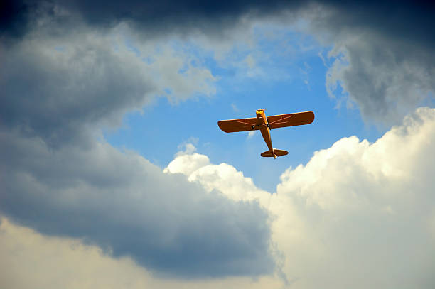 volant dans le trou - airplane stunt yellow flying photos et images de collection