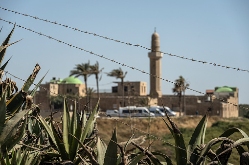 Sidne Ali Mosque in Israel with a pole and barbed wire in the foreground.