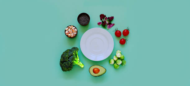 istock Ingredients for proper nutrition and empty white plate on green background. The concept of healthy diet or summer background. 1398673002