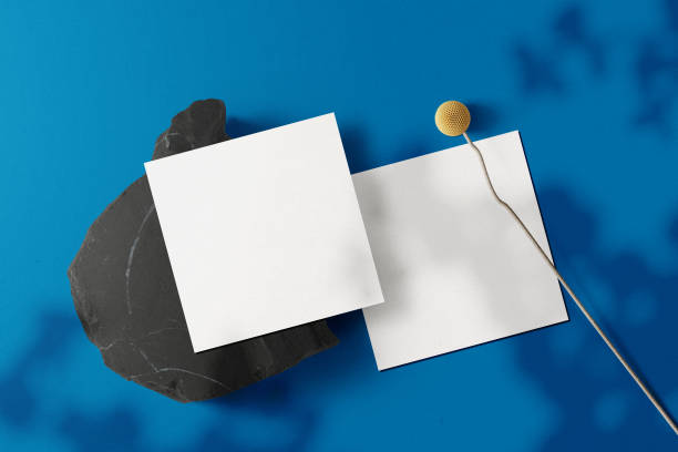 istock Clean minimal square flyer mockup on black stone with flower 1398673160