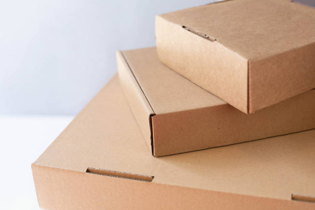 istock Three cardboard packing boxes stand stacked on top of each other on a gray background. 1398673309