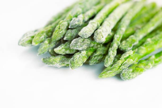 asparagi congelati su sfondo bianco. ortaggio. - cibi surgelati foto e immagini stock