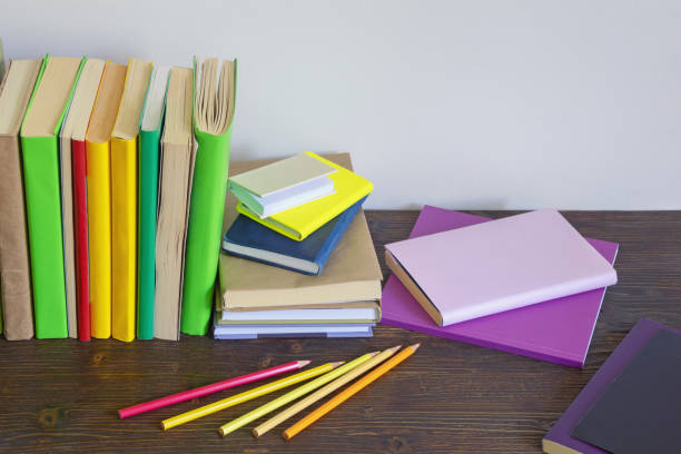 istock Different colorful books, notebooks and colored pencils on dark rustic table. Copy space 1398675131