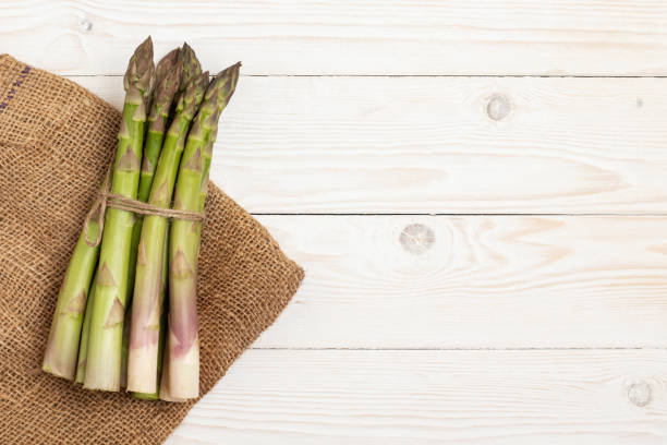 istock A bundle of cultivated asparagus on wooden table. 1398679060