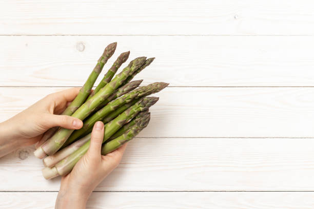 istock Cultivated asparagus stems in hands. 1398679071