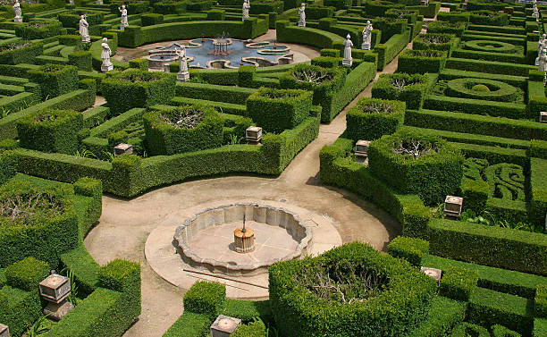 Intricate hedge maze with fountains and statues stock photo