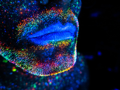 Close up of lips of a man with fluorescent painting on the face