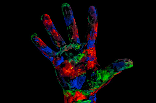 Human hand print on black background isolated close up, under UV lights