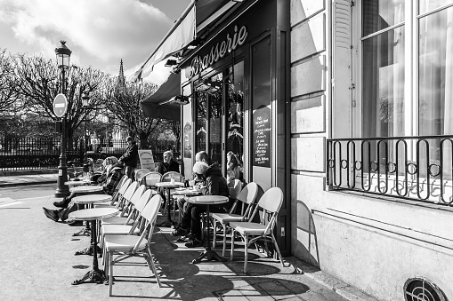 Paris, France - February 20, 2010: Parisians and tourists sitting in outdoor cafe in Paris
