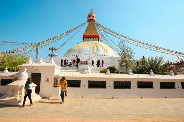 人々はネパールのカトマンズにあるボダナート仏塔の周りを歩きます。 - many colored prayer flags ストックフォトと画像