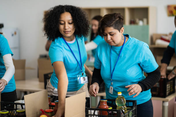 Female aid workers packing food donations stock photo