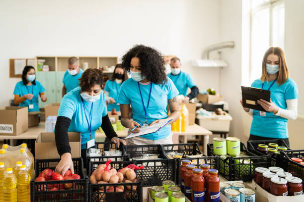 Volunteers soring donations during food drive stock photo