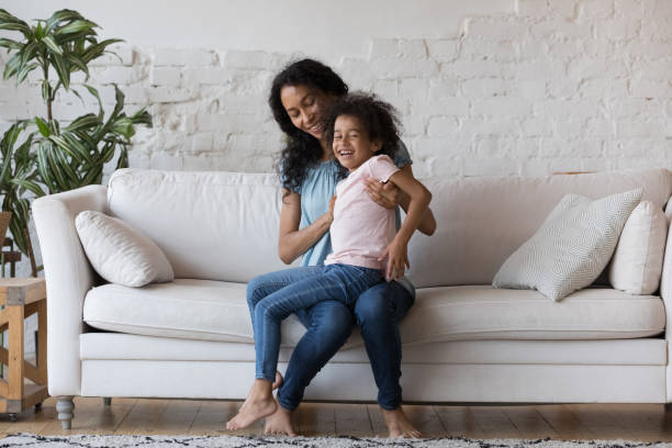 istock Cheerful African mom holding joyful daughter on lap 1398683718