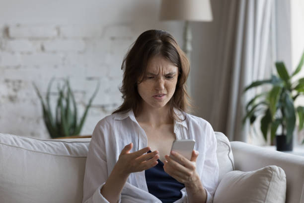 istock Confused annoyed customer girl using smartphone at home 1398683756