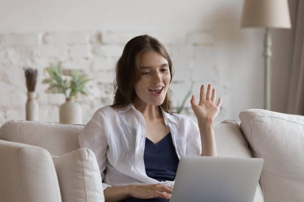 istock Happy joyful laptop user girl waving hand hello at webcam 1398683773