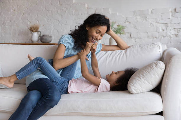 istock Joyful mom and kid having fun on home couch together 1398683842