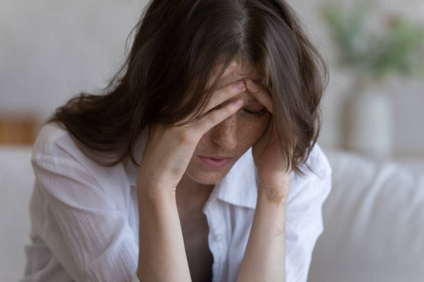 istock Tired frustrated millennial girl touching head, feeling headache 1398683895