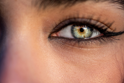 Extreme close up of young woman's green eye