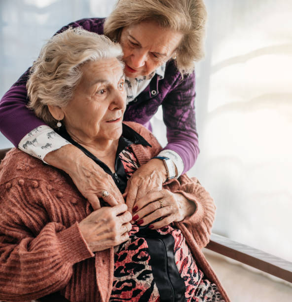 una donna abbraccia la sorella anziana in una casa di cura. concetto di famiglia e affetto nella vecchiaia. malattie mentali e degenerative. alzheimer - iberico sud europeo foto e immagini stock