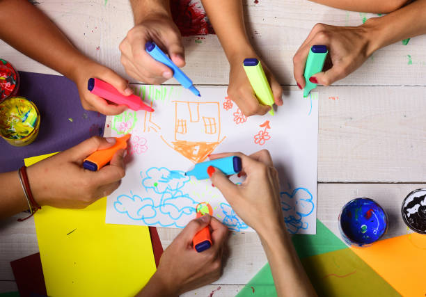 istock Artists wooden table with paints and colored paper 1398687404